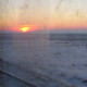 Sunset on snowy steppe photographed from inside a train.