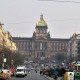 A large boulevard with cars passing on both sides and a pedstrian area in the middle constitute the square. In the background, the large building of the National Museum.