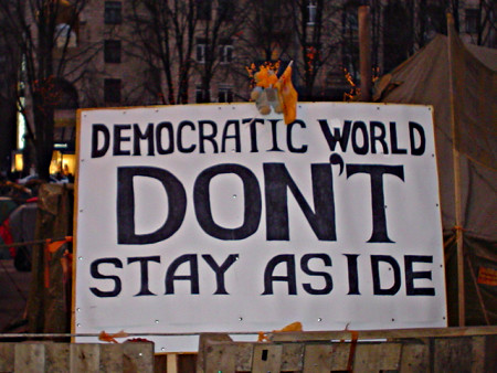 "Democratic world don't stay aside" written on a poster.