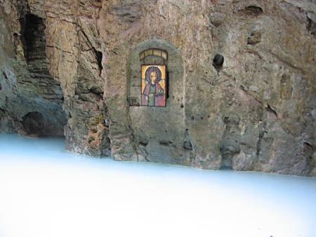 An orthodox icon is hanged at the mountain wall about one meter above the water level, not reachable by any path.