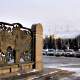 A square. On the left, a bronze bas-relief with Presidenz Nazarbaev swearing on the constitution. Snowy mountain tops in the background.