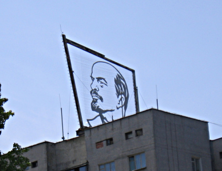 A representation of the head of Lenin in metal wires stands over a building. 