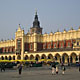 Picture of a big yellow arched building in a large square.