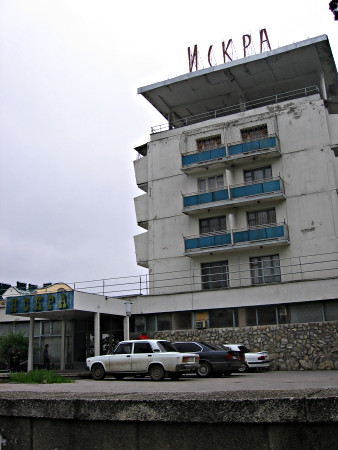 A soviet style five-storey high buliding, unrenovated. The sanatorium's name, "Iskra", is written on top of the building and on the entrance.