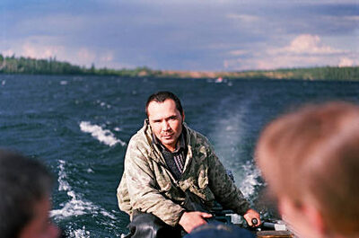 A young man is drive a motorboat on a lake